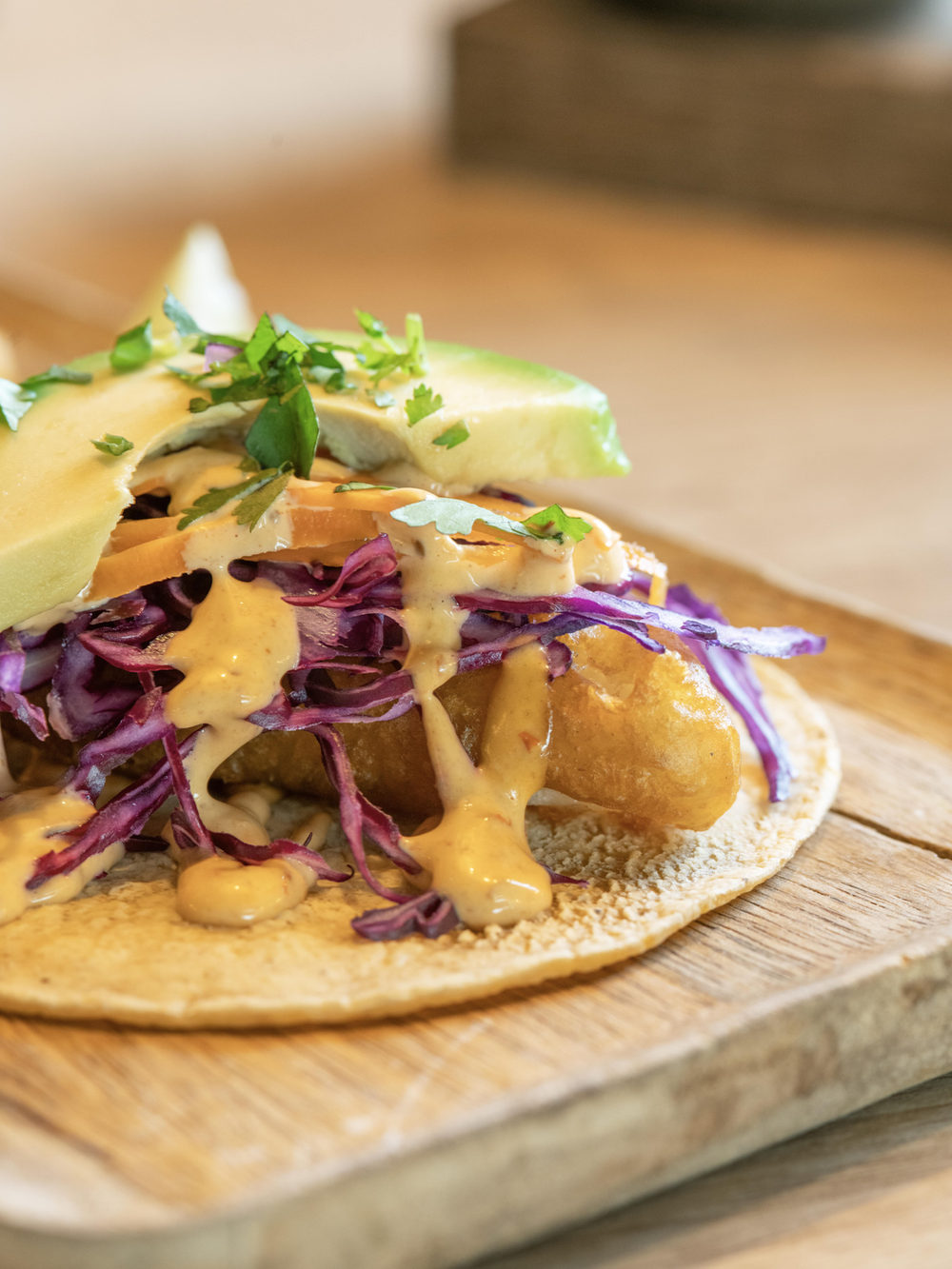 Taco garni de chou rouge, avocat et sauce crémeuse