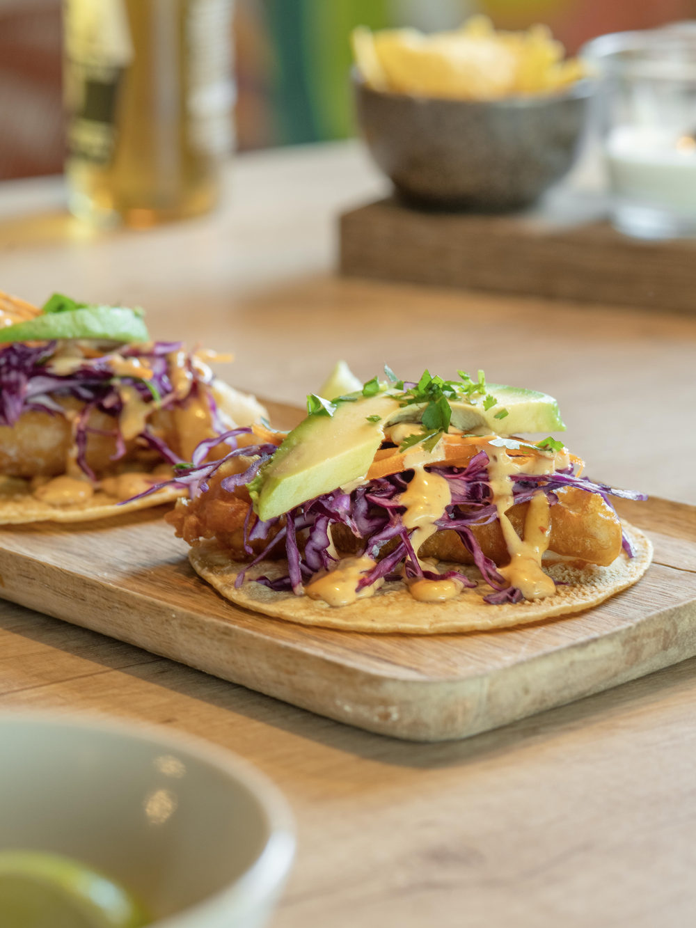 Tacos mit Rotkohl, Avocado und Sauce, auf einem Brett serviert