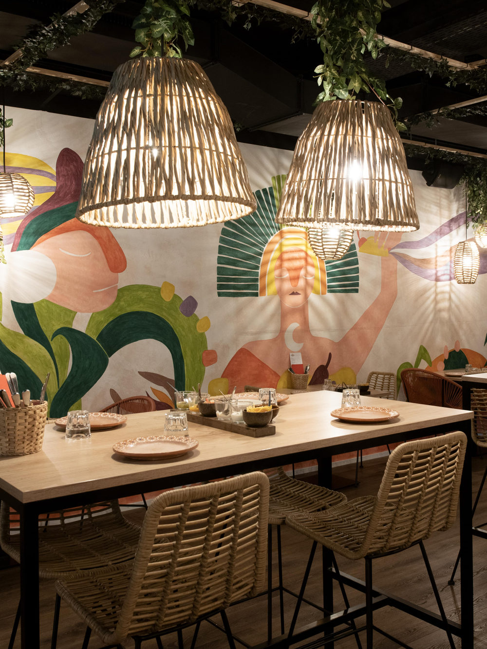 Una sala del restaurante ante el mural de colores