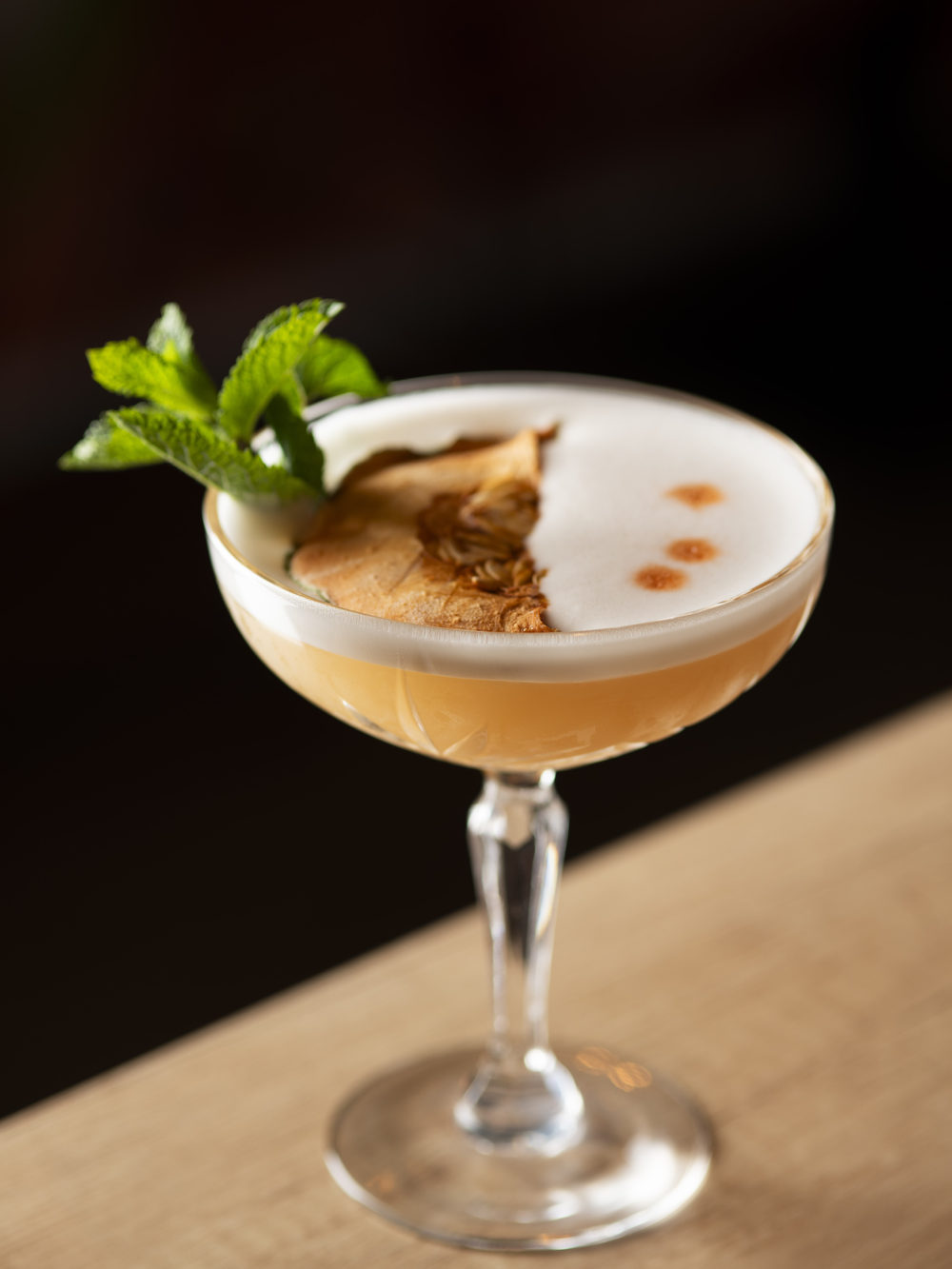 Cocktail signature servito al bar, schiuma e guarnizione fresca